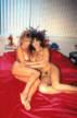 two lesbian gay girls laying on the bed and holding each other